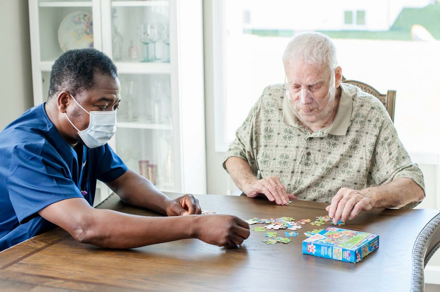 Caregiver working puzzle with senior patient