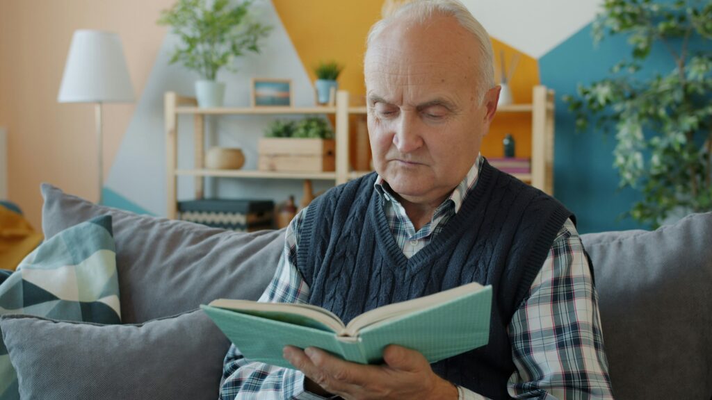 An older adult reading a book.